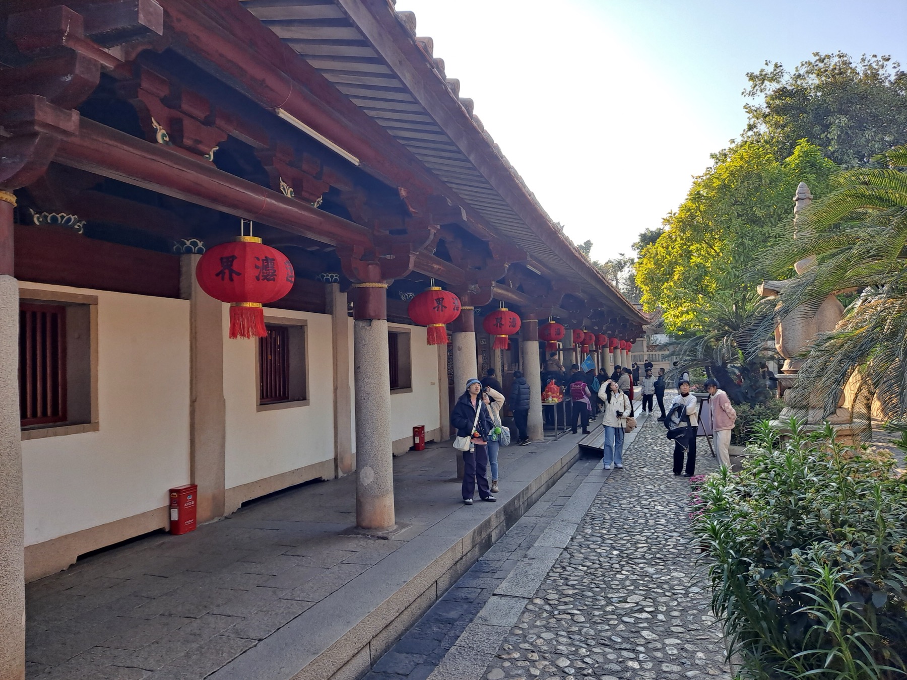 Lantern-lined cloister and visitors inside Quanzhou Kaiyuan Temple